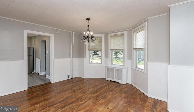 332 E Conestoga Rd, Wayne, PA 19087 - unfurnished dining area featuring radiator heating unit, ornamental molding, a chandelier, wood finished floors, and wainscoting