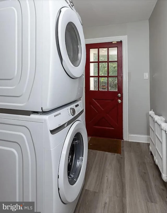 332 E Conestoga Rd, Wayne, PA 19087 - laundry room featuring stacked washing machine and dryer, radiator, and wood finished floors