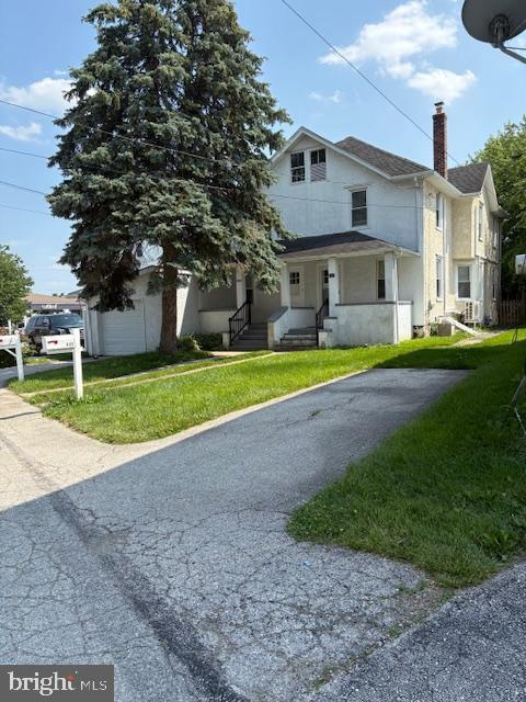 332 E Conestoga Rd, Wayne, PA 19087 - view of front of home with stucco siding, a chimney, and a front lawn