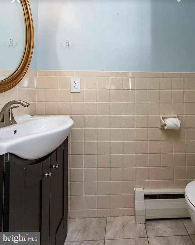 332 E Conestoga Rd, Wayne, PA 19087 - half bathroom featuring baseboard heating, tile walls, vanity, and wainscoting