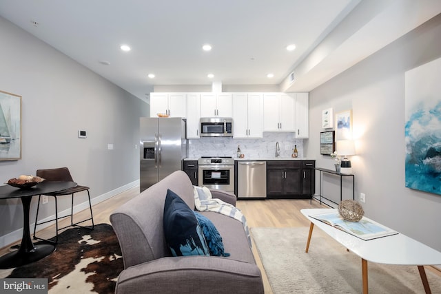 505 Kennedy St NW Unit B02, Washington, DC 20011 - kitchen with appliances with stainless steel finishes, light wood-type flooring, decorative backsplash, white cabinetry, and recessed lighting