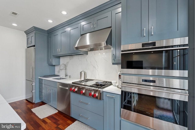 406 Regatta Dr, Philadelphia, PA 19146 - kitchen featuring stainless steel appliances, extractor fan, dark wood-style floors, tasteful backsplash, and light countertops