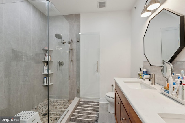 406 Regatta Dr, Philadelphia, PA 19146 - bathroom featuring tiled shower, double vanity, decorative backsplash, and tile patterned flooring