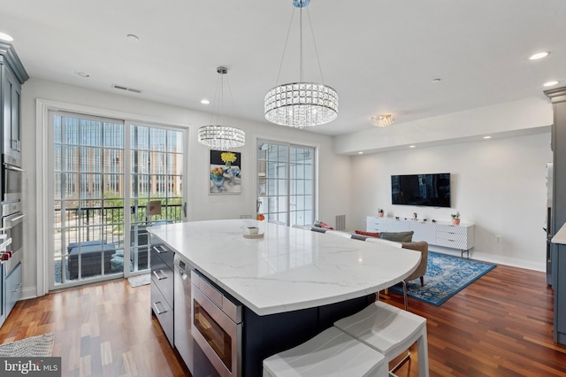 406 Regatta Dr, Philadelphia, PA 19146 - kitchen with stainless steel microwave, wood finished floors, a kitchen island, recessed lighting, and a chandelier