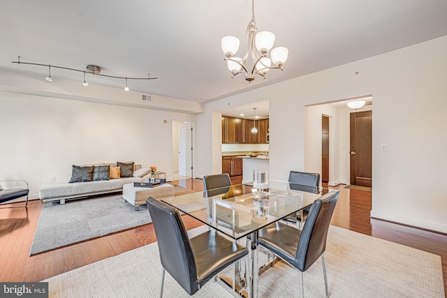 12500 Park Potomac Ave Unit 409, Potomac, MD 20854 - dining area with a chandelier and light wood-type flooring