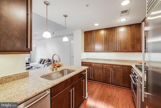 12500 Park Potomac Ave Unit 409, Potomac, MD 20854 - kitchen with wood finished floors, stainless steel appliances, light stone counters, decorative light fixtures, and recessed lighting