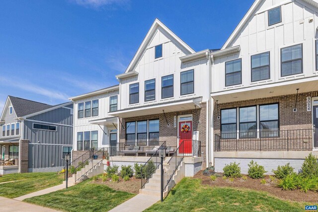 3028 Horizon Rd, Charlottesville, VA 22902 - townhome / multi-family property featuring board and batten siding, brick siding, a porch, and a front lawn