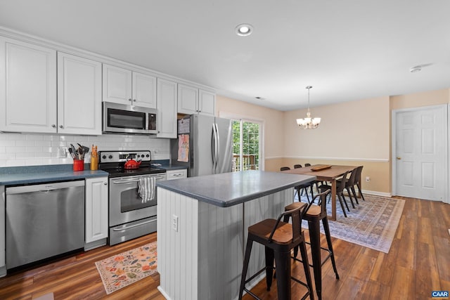 295 Homestead Ln, Charlottesville, VA 22902 - kitchen with stainless steel appliances, dark countertops, white cabinetry, a chandelier, and dark wood finished floors