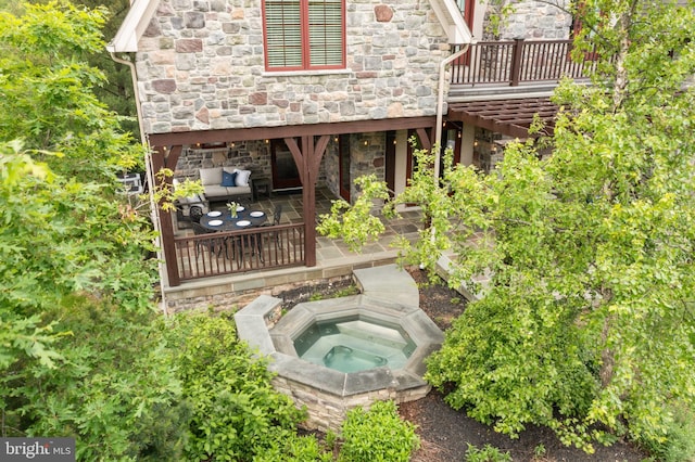 3054 Jordan Rd, Orefield, PA 18069 - back of house with stone siding, an in-ground hot tub, a patio area, and a wooden deck