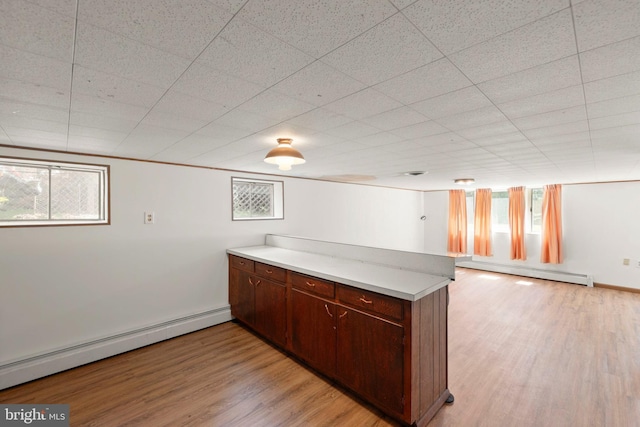 412 Fairview Ave, Winchester, VA 22601 - kitchen featuring a baseboard radiator, a peninsula, light wood-style floors, and light countertops