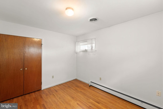 412 Fairview Ave, Winchester, VA 22601 - unfurnished bedroom with a baseboard heating unit, a closet, and light wood-style floors