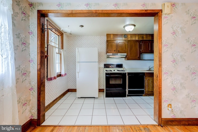 257 Westpark Ln, Clifton Heights, PA 19018 - kitchen featuring freestanding refrigerator, gas range, under cabinet range hood, black dishwasher, and wallpapered walls