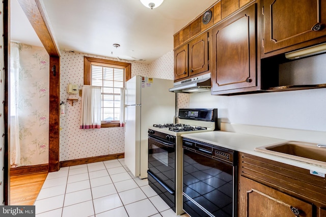 257 Westpark Ln, Clifton Heights, PA 19018 - kitchen featuring black appliances, under cabinet range hood, wallpapered walls, light countertops, and light tile patterned flooring