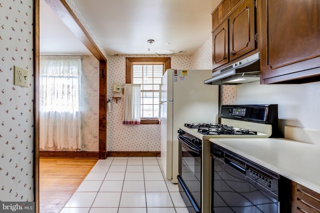 257 Westpark Ln, Clifton Heights, PA 19018 - kitchen with wallpapered walls, under cabinet range hood, dishwasher, range with gas stovetop, and light countertops