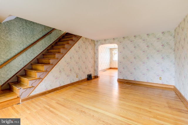 257 Westpark Ln, Clifton Heights, PA 19018 - staircase with wood finished floors, arched walkways, and wallpapered walls