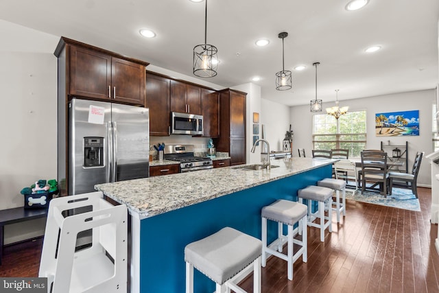 6203 Posey St, Frederick, MD 21703 - kitchen featuring stainless steel appliances, recessed lighting, a breakfast bar, dark brown cabinetry, and light stone countertops
