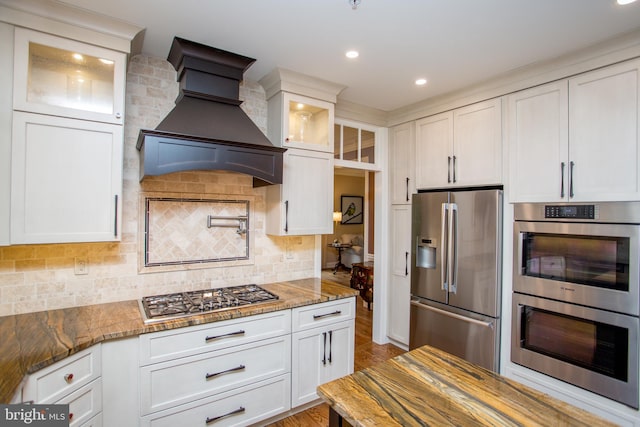 3879 Charter Club Dr, Doylestown, PA 18902 - kitchen with stainless steel appliances, premium range hood, glass insert cabinets, white cabinets, and light stone counters