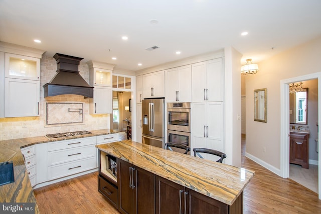 3879 Charter Club Dr, Doylestown, PA 18902 - kitchen featuring stainless steel appliances, custom range hood, decorative backsplash, white cabinetry, and recessed lighting