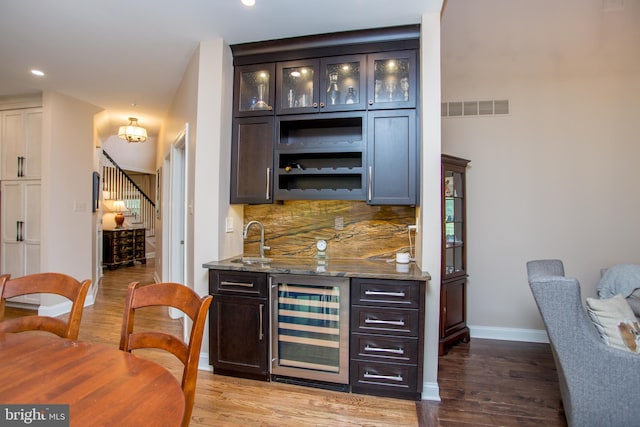 3879 Charter Club Dr, Doylestown, PA 18902 - indoor wet bar featuring wine cooler, decorative backsplash, light wood finished floors, recessed lighting, and stairs