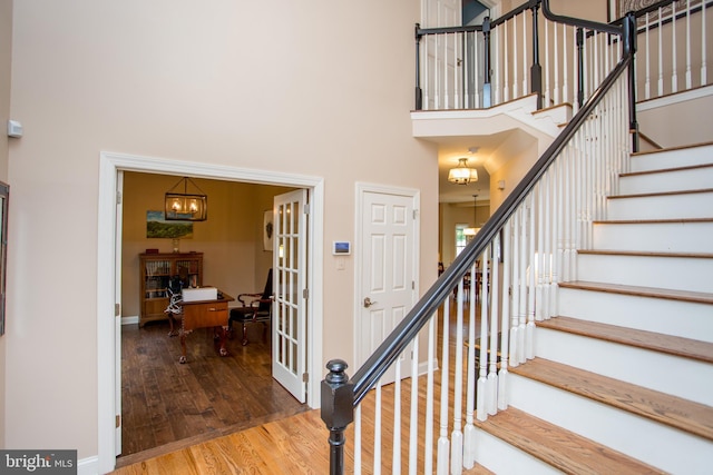 3879 Charter Club Dr, Doylestown, PA 18902 - stairs with wood finished floors, a high ceiling, and a chandelier