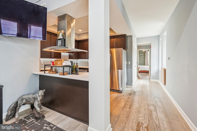3240 Hiatt Pl NW Unit 4, Washington, DC 20010 - kitchen with island range hood, freestanding refrigerator, light wood-type flooring, light countertops, and dark brown cabinetry