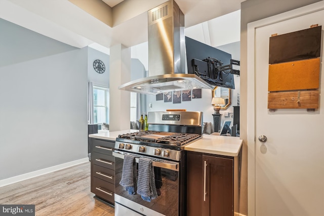 3240 Hiatt Pl NW Unit 4, Washington, DC 20010 - kitchen featuring stainless steel gas range, island exhaust hood, light wood-style flooring, and light countertops