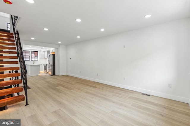 2012 S Mildred St, Philadelphia, PA 19148 - unfurnished living room with stairs, light wood-style flooring, and recessed lighting