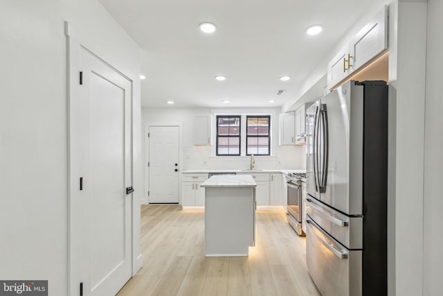 2012 S Mildred St, Philadelphia, PA 19148 - kitchen featuring appliances with stainless steel finishes, a kitchen island, white cabinetry, light wood-style floors, and recessed lighting