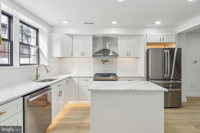 2012 S Mildred St, Philadelphia, PA 19148 - kitchen featuring stainless steel appliances, wall chimney exhaust hood, light wood finished floors, light stone counters, and white cabinets
