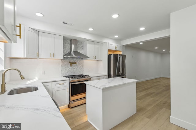 2012 S Mildred St, Philadelphia, PA 19148 - kitchen with stainless steel appliances, wall chimney range hood, white cabinetry, light stone counters, and recessed lighting