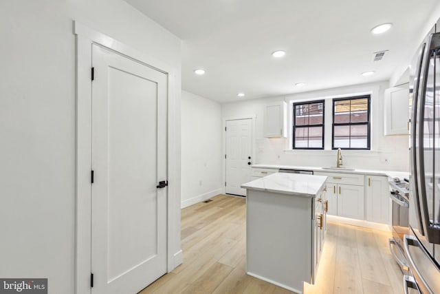 2012 S Mildred St, Philadelphia, PA 19148 - kitchen featuring tasteful backsplash, light wood-style flooring, a kitchen island, white cabinets, and recessed lighting