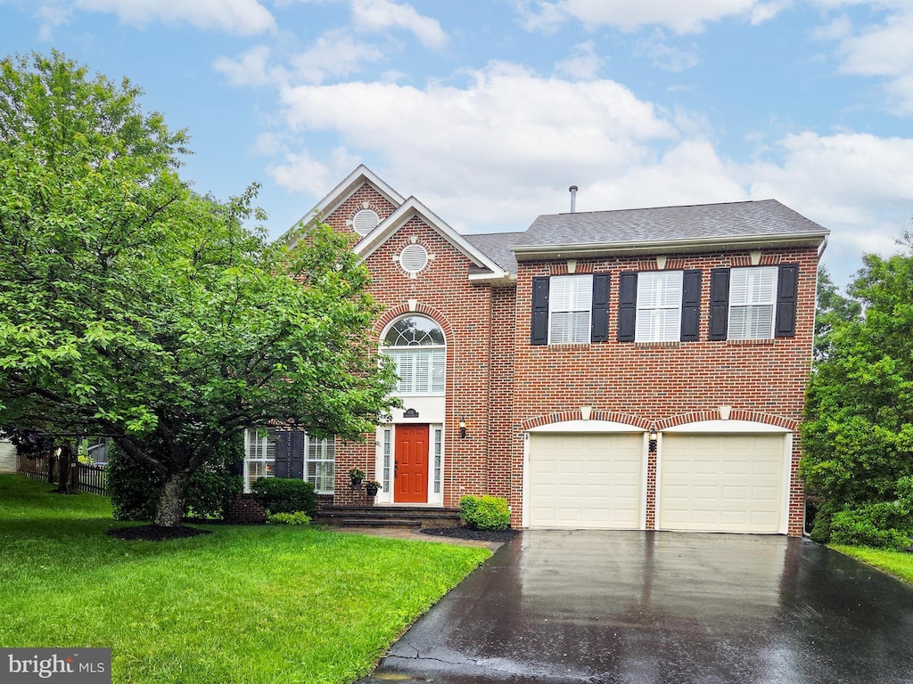 6341 Claridge Dr N, Frederick, MD 21701 - colonial inspired home with asphalt driveway, a front lawn, an attached garage, brick siding, and a shingled roof