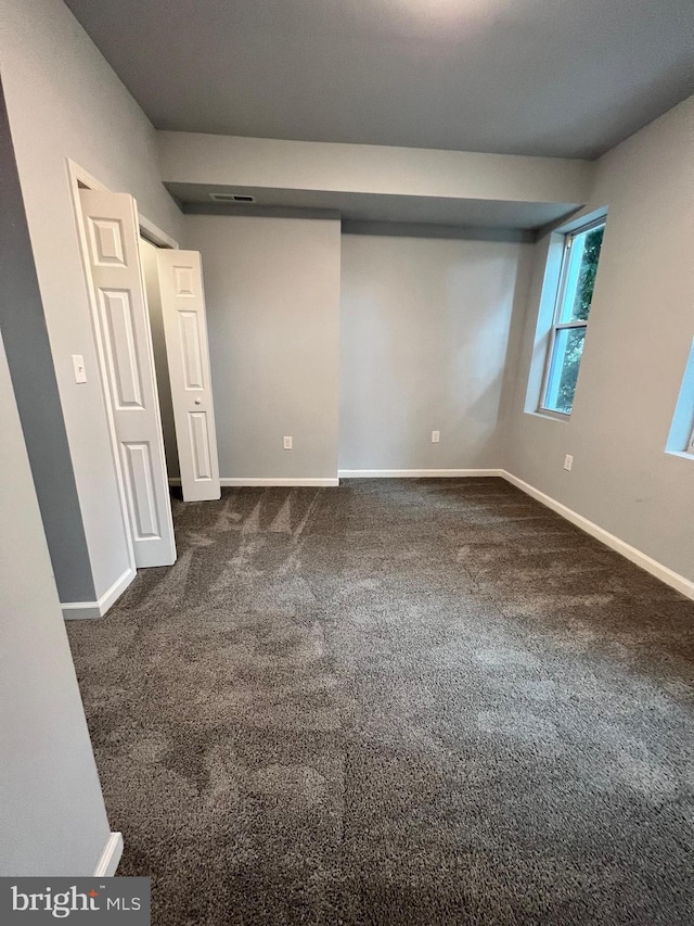 1107 N Fulton Ave, Baltimore, MD 21217 - unfurnished bedroom featuring dark carpet and baseboards