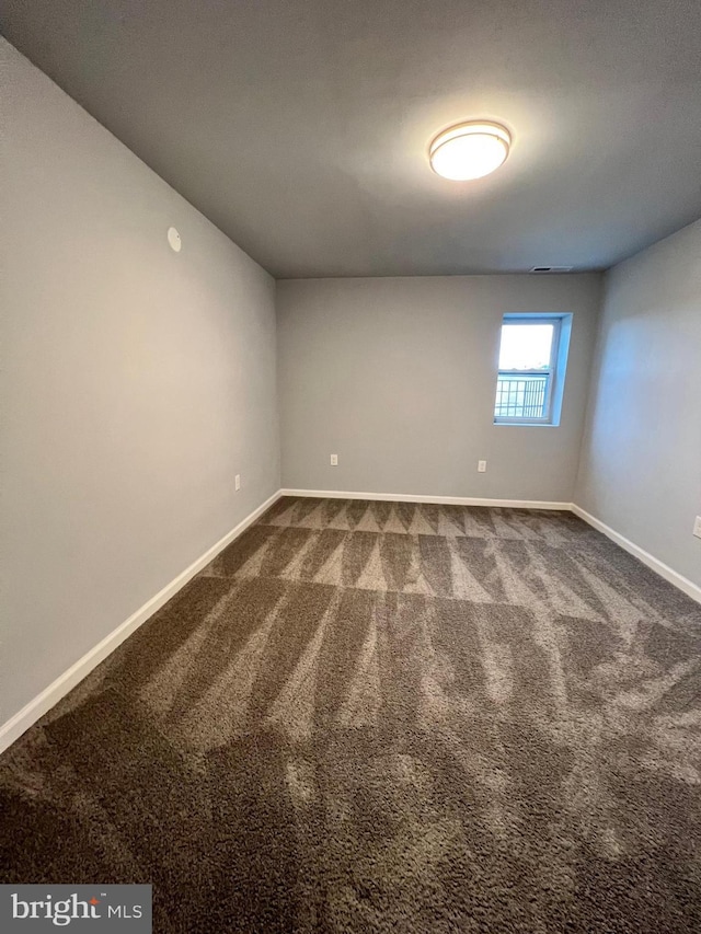 1107 N Fulton Ave, Baltimore, MD 21217 - empty room featuring dark colored carpet and baseboards