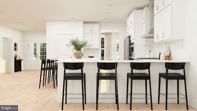 36 Aaron Truehart Way, Titusville, NJ 08560 - kitchen with wall chimney range hood, a breakfast bar, light wood-style floors, white cabinets, and recessed lighting