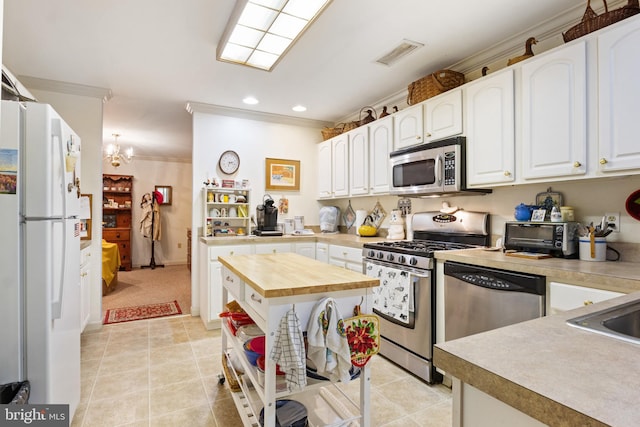 324 Winners Cir Unit 324, Red Lion, PA 17356 - kitchen with appliances with stainless steel finishes, wood counters, ornamental molding, light tile patterned floors, and white cabinetry