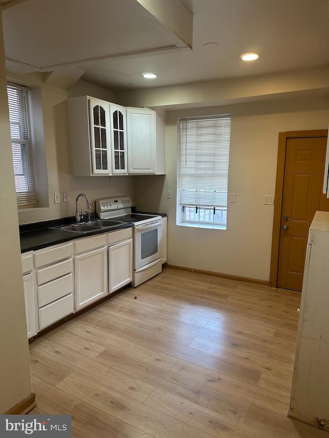 609 S Monroe St, Baltimore, MD 21223 - kitchen with electric stove, white cabinets, glass insert cabinets, recessed lighting, and light wood-style flooring