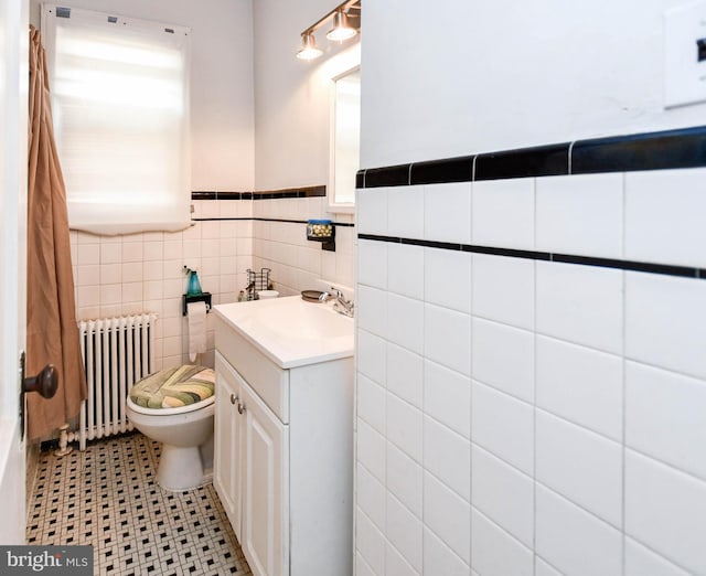 455 Lebaum St SE, Washington, DC 20032 - bathroom featuring radiator, vanity, tile walls, and wainscoting