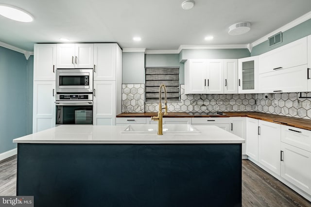 30 Scott Ct, Chesterbrook, PA 19087 - kitchen with stainless steel appliances, ornamental molding, dark wood-style flooring, decorative backsplash, and wood counters