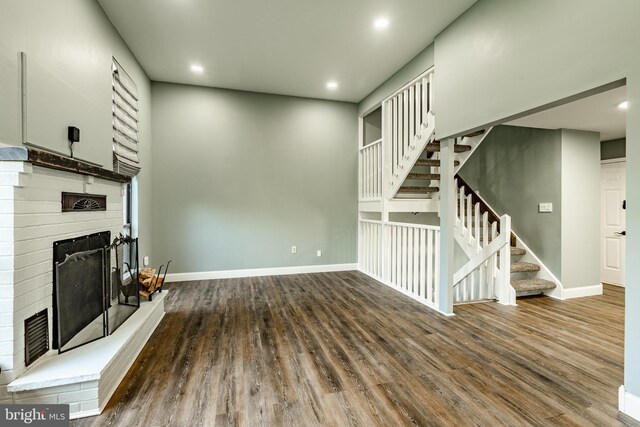 30 Scott Ct, Chesterbrook, PA 19087 - unfurnished living room featuring a fireplace with raised hearth, stairs, wood finished floors, and recessed lighting