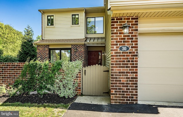 30 Scott Ct, Chesterbrook, PA 19087 - view of exterior entry featuring brick siding, roof with shingles, and an attached garage