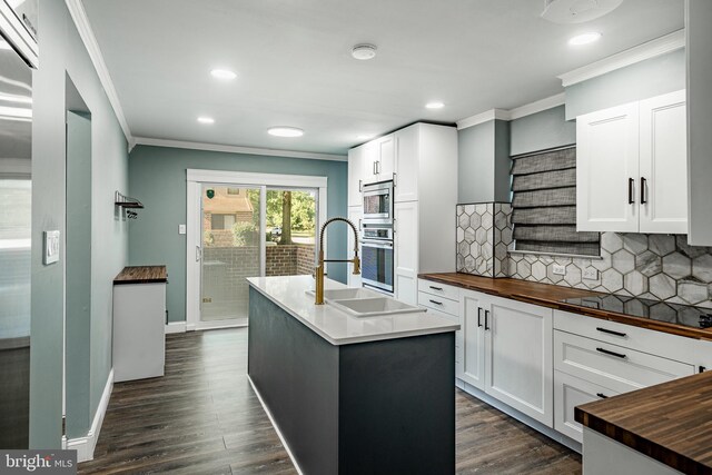 30 Scott Ct, Chesterbrook, PA 19087 - kitchen with butcher block counters, crown molding, appliances with stainless steel finishes, tasteful backsplash, and dark wood-style flooring