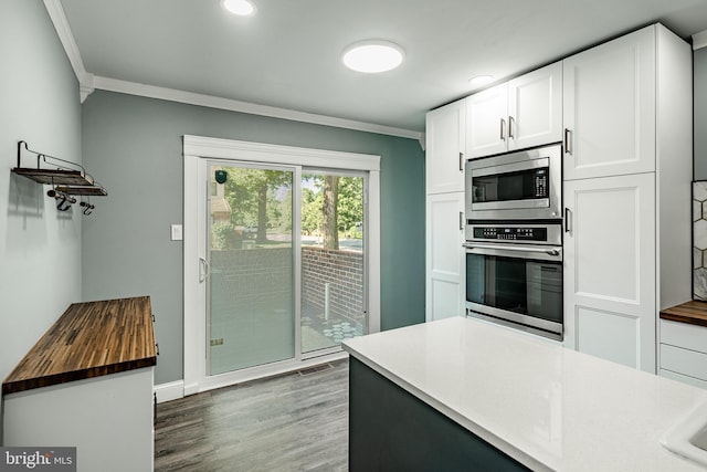 30 Scott Ct, Chesterbrook, PA 19087 - kitchen with appliances with stainless steel finishes, ornamental molding, butcher block countertops, white cabinetry, and wood finished floors