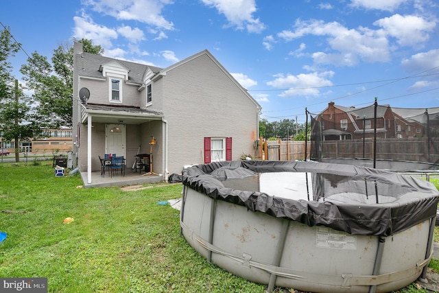2941 N 6th St, Harrisburg, PA 17110 - rear view of property with a fenced backyard, brick siding, a patio, a trampoline, and roof with shingles
