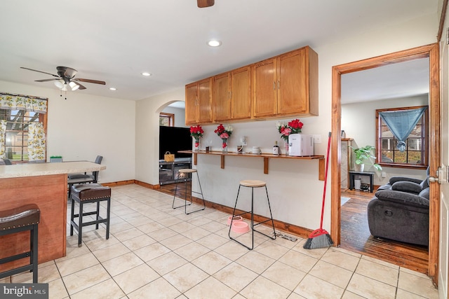 2941 N 6th St, Harrisburg, PA 17110 - kitchen with a ceiling fan, a kitchen bar, arched walkways, recessed lighting, and light tile patterned floors