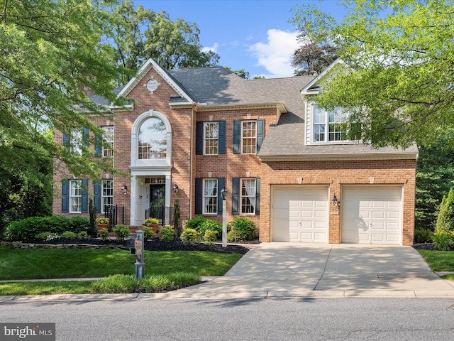 1509 Winfields Ln, Gambrills, MD 21054 - colonial house featuring concrete driveway, a garage, a shingled roof, brick siding, and a front yard