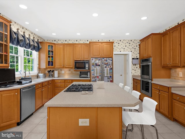 1509 Winfields Ln, Gambrills, MD 21054 - kitchen with appliances with stainless steel finishes, a breakfast bar, a center island, glass insert cabinets, and light tile patterned floors