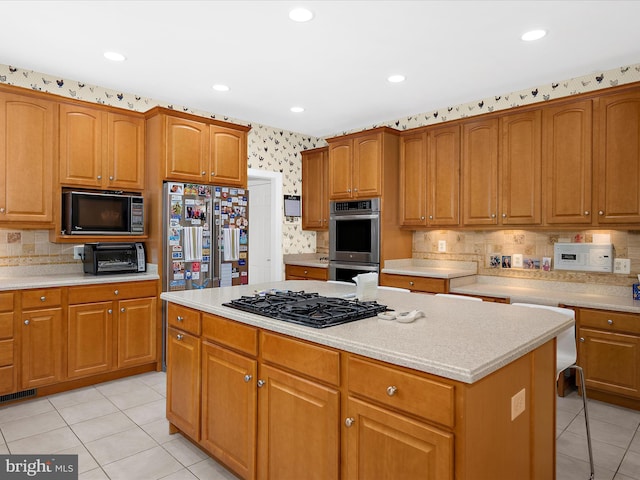 1509 Winfields Ln, Gambrills, MD 21054 - kitchen featuring black appliances, light tile patterned floors, a kitchen island, tasteful backsplash, and brown cabinets