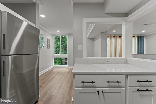 8677 Greenbelt Rd Unit 201, Greenbelt, MD 20770 - kitchen featuring freestanding refrigerator, light stone counters, light wood-style floors, white cabinetry, and recessed lighting