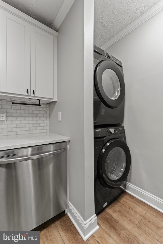8677 Greenbelt Rd Unit 201, Greenbelt, MD 20770 - laundry room with stacked washing machine and dryer, light wood-style floors, crown molding, and a textured ceiling